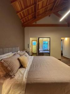a large bed in a bedroom with wooden ceilings at Terrace Chalés in Monte Verde