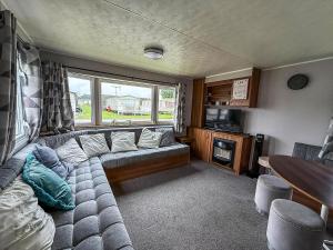 a living room with a couch and a table at Superb 8 Berth Caravan At Highfield Grange Ref 26706Wr in Clacton-on-Sea