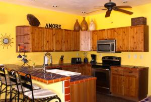 a kitchen with wooden cabinets and a stove top oven at Casa Arco Iris in La Choya