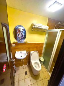 a man taking a picture of a bathroom with a toilet and sink at Condo 2Bedroom near Session with Free Own Parking in Baguio +18 photos