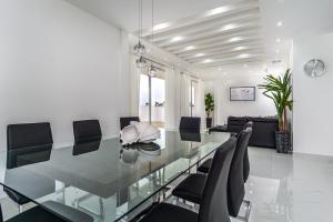 Un comedor con una mesa de cristal y sillas. en Ocean Pearl House, en Oshawa