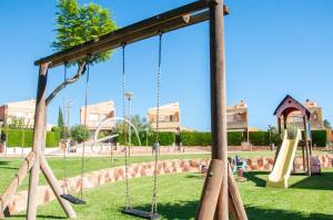 einen Spielplatz mit Schaukeln in einem Park in der Unterkunft Villa Almendros in Peñíscola
