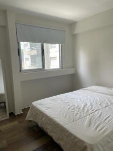 Una habitación blanca con una cama y una ventana en Departamento 1 dormitorio centrico, La Plata, en La Plata 4 fotos más