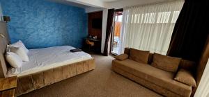 a bedroom with a bed and a couch at Primera Dru Hotel&Spa in Baia Mare
