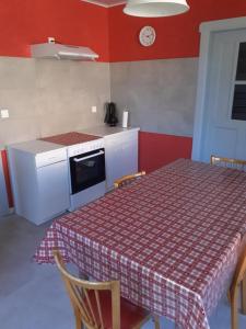 a kitchen with a table with a red wall at Gîte Le Repos du Verrier in Wingen-sur-Moder