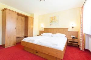 um quarto com uma cama grande e uma cabeceira em madeira em Appartments Reiter am See em Inzell