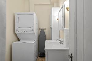 een witte badkamer met een wastafel en een wasmachine bij The 87th Townhome - Local Landmark Property in Portland +28 foto's