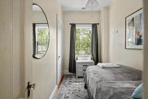 een slaapkamer met een bed, een spiegel en een raam bij The 87th Townhome - Local Landmark Property in Portland