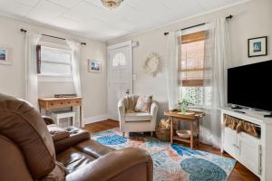 a living room with a couch and a flat screen tv at Charming Centrally Located Seaside Retreat in Old Orchard Beach