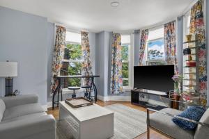 Una sala de estar con un sofá y un televisor. en Stylish Downtown Condo in a Historic Landmark Home, en Portland 8 fotos más