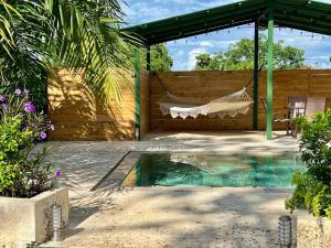 una hamaca en un patio trasero con piscina en Casa Blanca Manuel Antonio A3, en Manuel Antonio