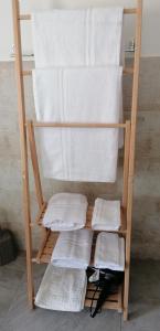 a towel rack with white towels on it at Mare&Vancanze in Quartu SantʼElena +17 photos