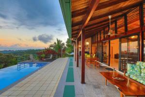 Una vista exterior de una villa con piscina. en Casa Kilimanjaro Nature, Amazing Views and 6 Acres, en Manuel Antonio