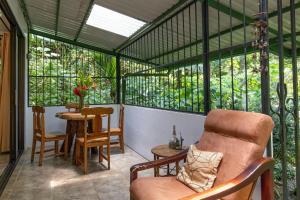 a screened in porch with a chair and a table at Mono Vista At Jungle Creek Chill out in the Jungle in Manuel Antonio