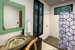 ein Badezimmer mit Waschbecken und Spiegel in der Unterkunft Casa Pura Vida Manuel Antonio in Manuel Antonio + 16 Fotos