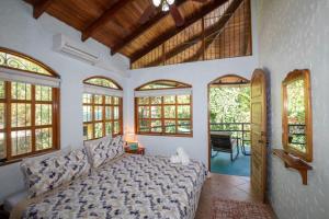 ein Wohnzimmer mit einem Bett und einigen Fenstern in der Unterkunft Casa Pura Vida Manuel Antonio in Manuel Antonio