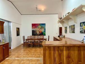 a kitchen and dining room with a painting on the wall at Finca Terra, Private Country Home, Mountain Views and Pool in Naranjito