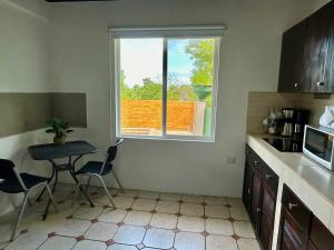 a small kitchen with a table and a window at Casa Blanca Manuel Antonio B3, Central, Pool, Gated in Manuel Antonio