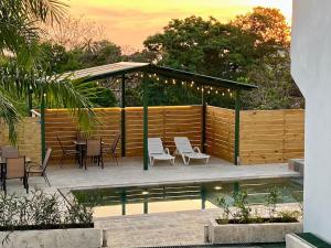 a gazebo with chairs and tables next to a pool at Casa Blanca Manuel Antonio B3, Central, Pool, Gated in Manuel Antonio