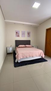 隆德里纳Lilly Queen I的卧室里有一张床，上面铺着粉色毯子