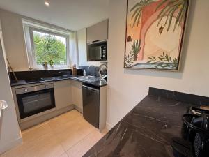 a kitchen with a sink and a stove top oven at Appartement Caen proche Gare in Caen