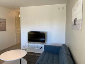 a living room with a blue couch and a tv at Modern Apartment for 2 with Sauna in Kemi