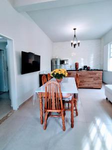 a dining room with a table and chairs and a kitchen at Flats Jardim de Ramos em Paraty, RJ in Paraty