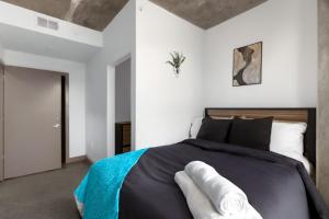 Schlafzimmer mit einem Bett mit schwarzer und weißer Bettwäsche in der Unterkunft Prime 2BR Stay Five Points and Nightlife 7th in Birmingham + 31 Fotos