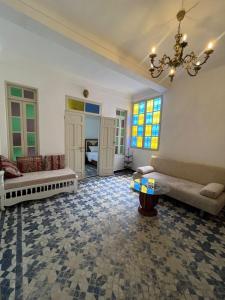 a living room with two couches and a chandelier at Dar Latifa in Fès