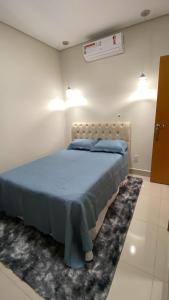 a bedroom with a bed with a blue comforter at Royal Lion Bedroom in Londrina