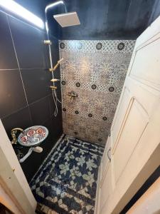 a bathroom with a shower with a tiled floor at Dar Latifa in Fès