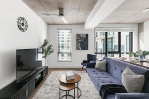 バーミングハムにあるModern 3BR Condo Five Points South Gemの青いソファとテーブルのあるリビングルーム