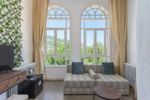 un salon avec un canapé et deux fenêtres dans l'établissement LAuberge de Douma Full House in Batroun, à Douma
