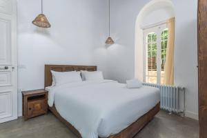 une chambre avec un grand lit blanc et une fenêtre dans l'établissement LAuberge de Douma Full House in Batroun, à Douma