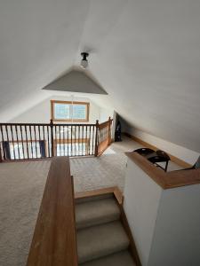 an attic room with stairs and a window at The Woodland Loft at Falmouth in Pleasant Hill