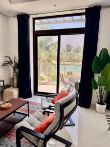 a living room with two chairs and a table at Stylish 2BR in Hawana Salalah with Beautiful Balcony in Wādī Khasbar