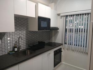 グランド・アンスにあるAtrium Apartments - Sorrel Loftのキッチン(シンク付)、壁掛けテレビが備わります。