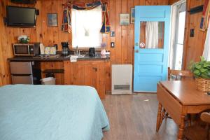 a kitchen with a bed and a table in a room at Little Miss Cottages - Studio in Old Orchard Beach