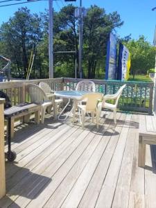 a patio with a table and chairs on a deck at Little Miss Cottages - 173 House in Old Orchard Beach