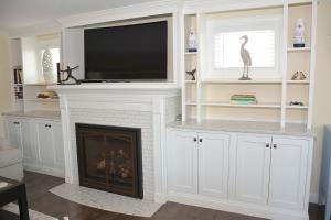 a living room with a fireplace with a flat screen tv at Little Miss Cottages - 68 East Grand Luxury Condo in Old Orchard Beach +3 photos