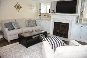 a living room with a couch and a fireplace at Little Miss Cottages - 68 East Grand Luxury Condo in Old Orchard Beach