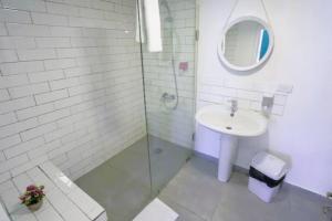 a white bathroom with a sink and a mirror at Spirit - 2-BR Apt & Balcony in Mar Mikhael in Al Mudawwar +12 photos