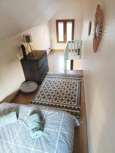 Una habitación abuhardillada con una cama, un escritorio y una mesa. en Studio Cosy, en Saint-Quay-Portrieux