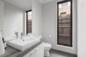 a white bathroom with a sink and a toilet at Modern Comfort Patio and Workstation with Garage in North Lakes +27 photos