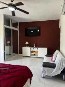 a bedroom with a bed and a flat screen tv at casa moderna y campestre con piscina y patio serca a la playa in Muñoz