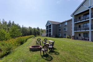 a group of benches in a yard next to a building at Black Beach Inn by GrandStay in Silver Bay