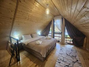 a bedroom with a bed in a wooden room at Shelva Cottage kazbegi in P'khelshe