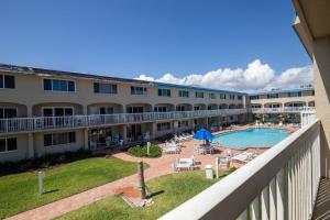 a view of the courtyard of a hotel with a swimming pool at Beachfront Comfort with Pool, Balcony & Steps to Flagler Avenue in Chicken Island