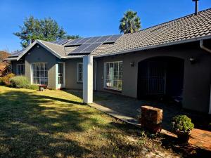 una casa con paneles solares en el techo en Aquasaints Guest Lodge, en Johannesburgo