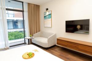 ein Wohnzimmer mit einem Stuhl und einem TV in der Unterkunft MYAN Villa Phòng nghỉ 3 Vinhomes Ocean Park 3 in Ðình Loan